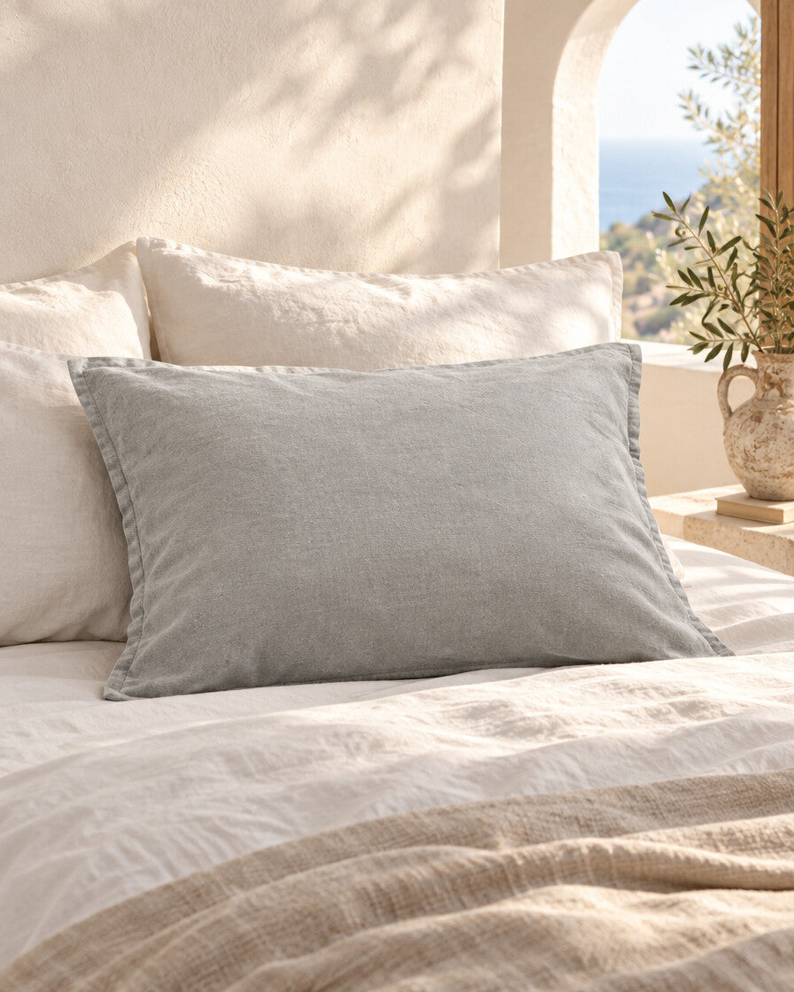 Mist grey French linen pillowcase, styled in a sun-washed Mediterranean bedroom