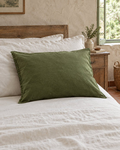 Moss green French linen pillowcase, styled in a relaxed European country-house bedroom