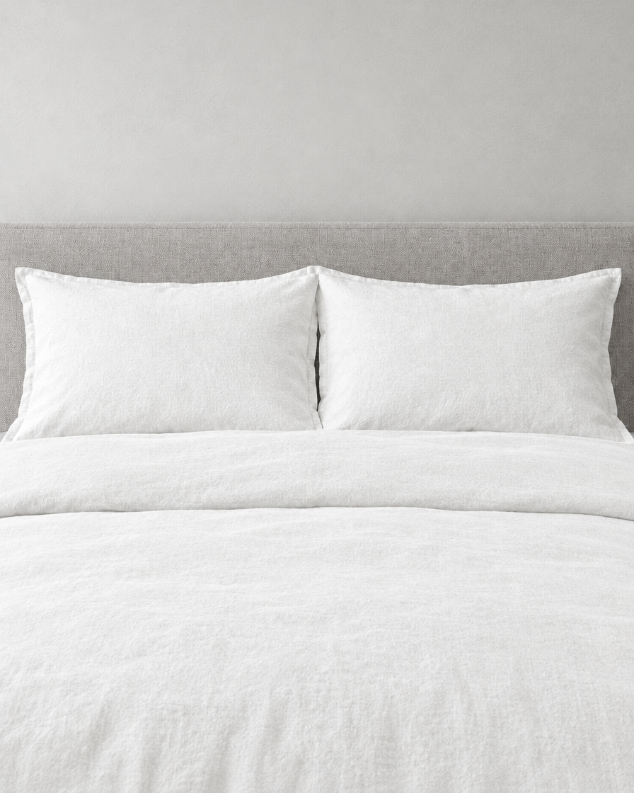 Snow white French linen pillowcases on a snow white linen bed, front view