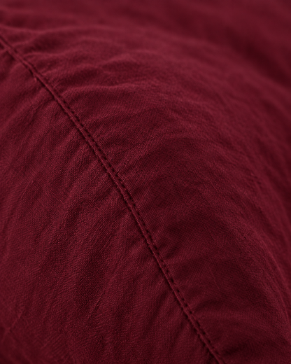 Macro of the stitched seam on a Burgundy Red pillow in plain cotton pillowcases.