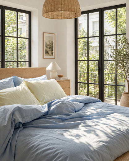 Blue-grey plain cotton bedding, styled in a bright modern townhouse bedroom