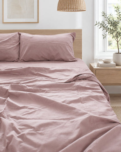 Dusty pink plain cotton pillows and duvet, styled in a bright modern townhouse bedroom