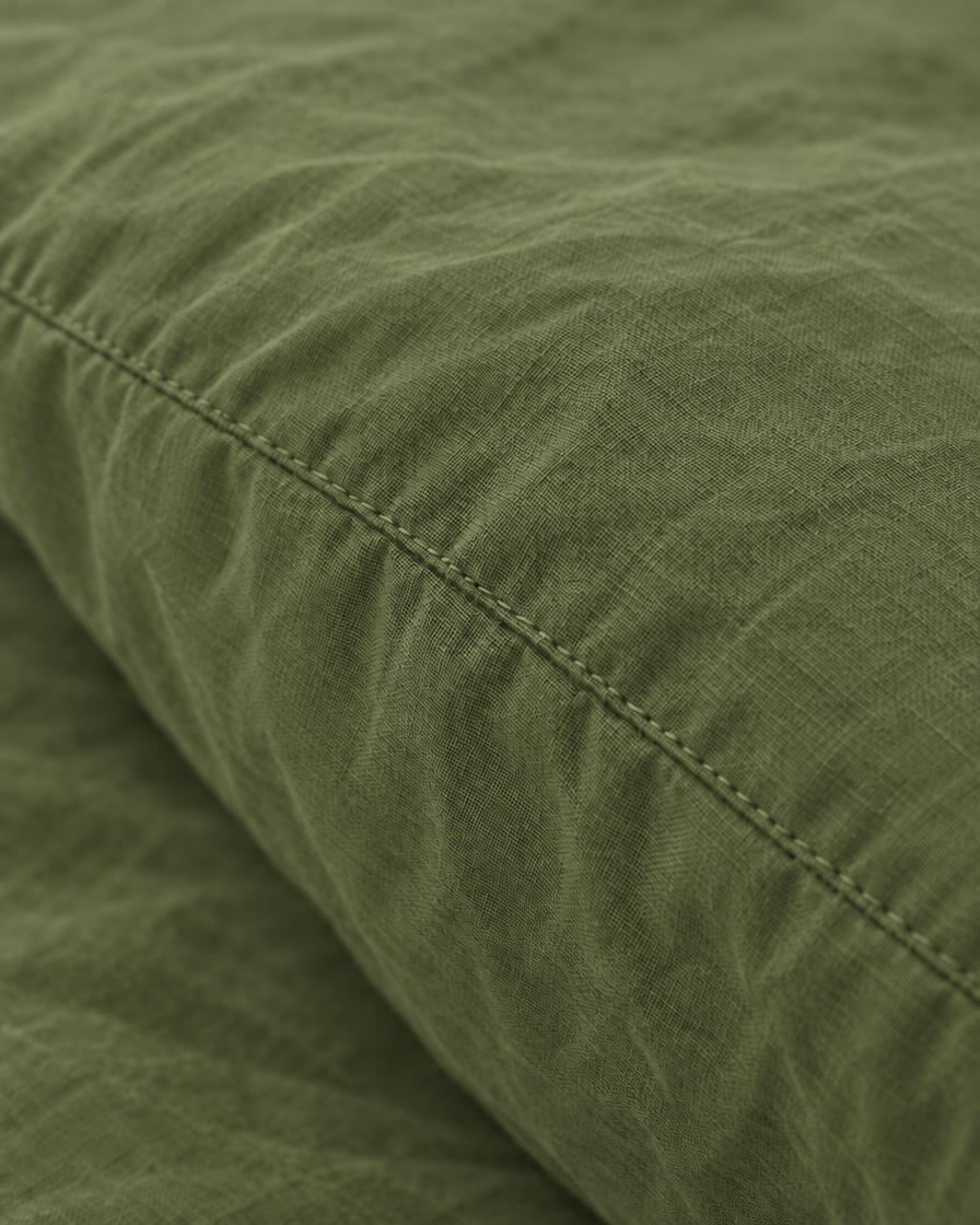 Macro of the stitched seam on an Olive pillow in plain cotton pillowcases.