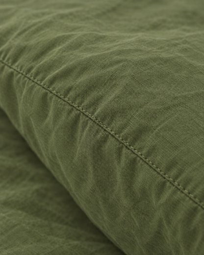 Macro of the stitched seam on an Olive pillow in plain cotton pillowcases.