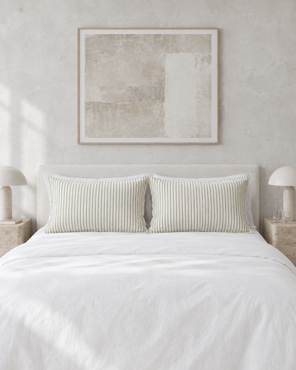 Green Pinstripe cloud cotton pillowcases on rectangular pillows by a limewashed wall, white bedding and mushroom lamps.