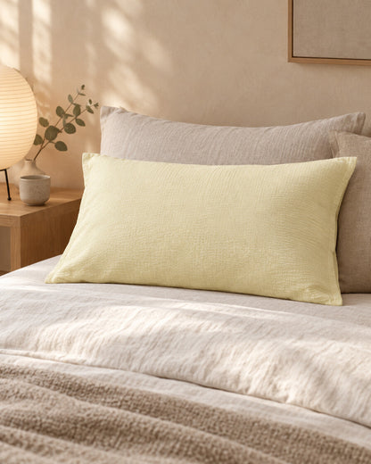 Vanilla cloud cotton pillowcase in soft pale yellow, styled in a serene Japandi bedroom