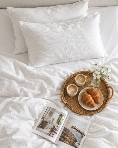 White Cloud Cotton pillowcase pair on rectangular pillows, seen from above with a breakfast tray and magazine