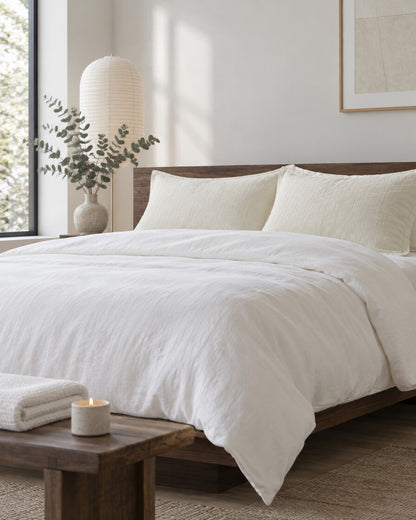 Cream cloud cotton pillowcases in a calm Japandi bedroom on a low dark-oak bed