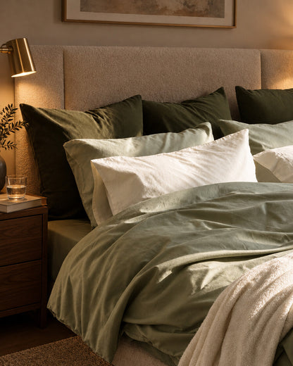 Olive green and cream silky cotton pillows, styled in a boutique-hotel suite