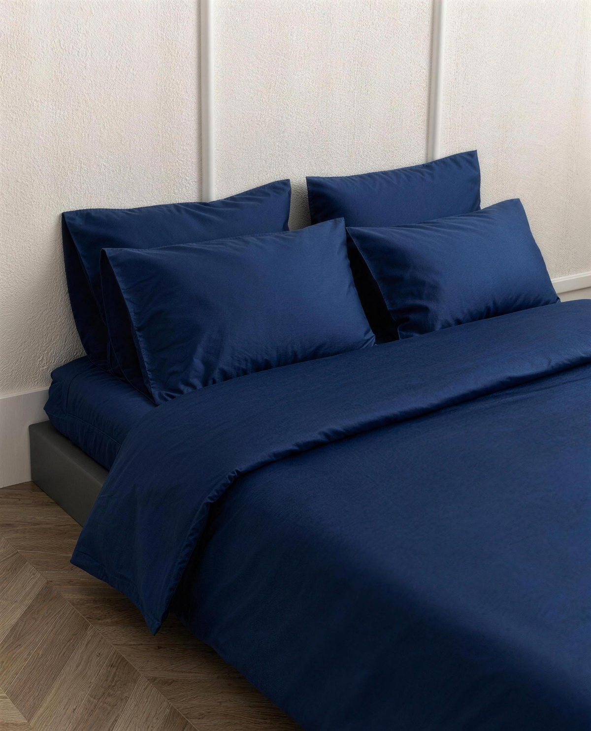 Marine Blue silky cotton sateen pillowcases on a bed