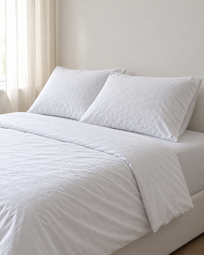 Milky White Pillowcase Pair - Silky Cotton made up on a bed in a calm, light bedroom