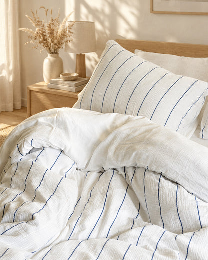 Cream pinstripe cloud cotton pillow and duvet, styled in a calm sunlit Scandinavian bedroom