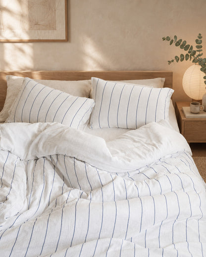 Cream pinstripe cloud cotton bedding, rumpled, styled in a serene Japandi bedroom