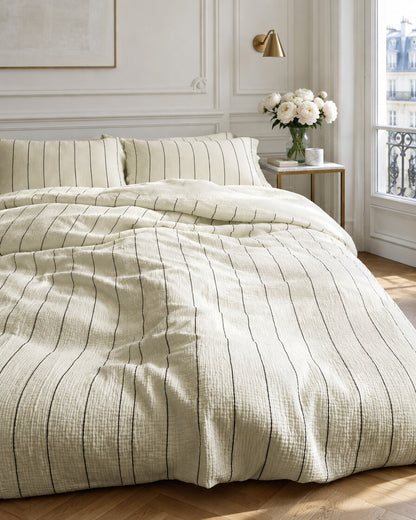 Cream pinstripe cloud cotton bedding set in a Parisian bedroom with panelled walls and fresh peonies