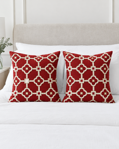 Two Red & Ivory Lattice Embroidery Ramie Cotton cushion covers on a made bed with white bedding