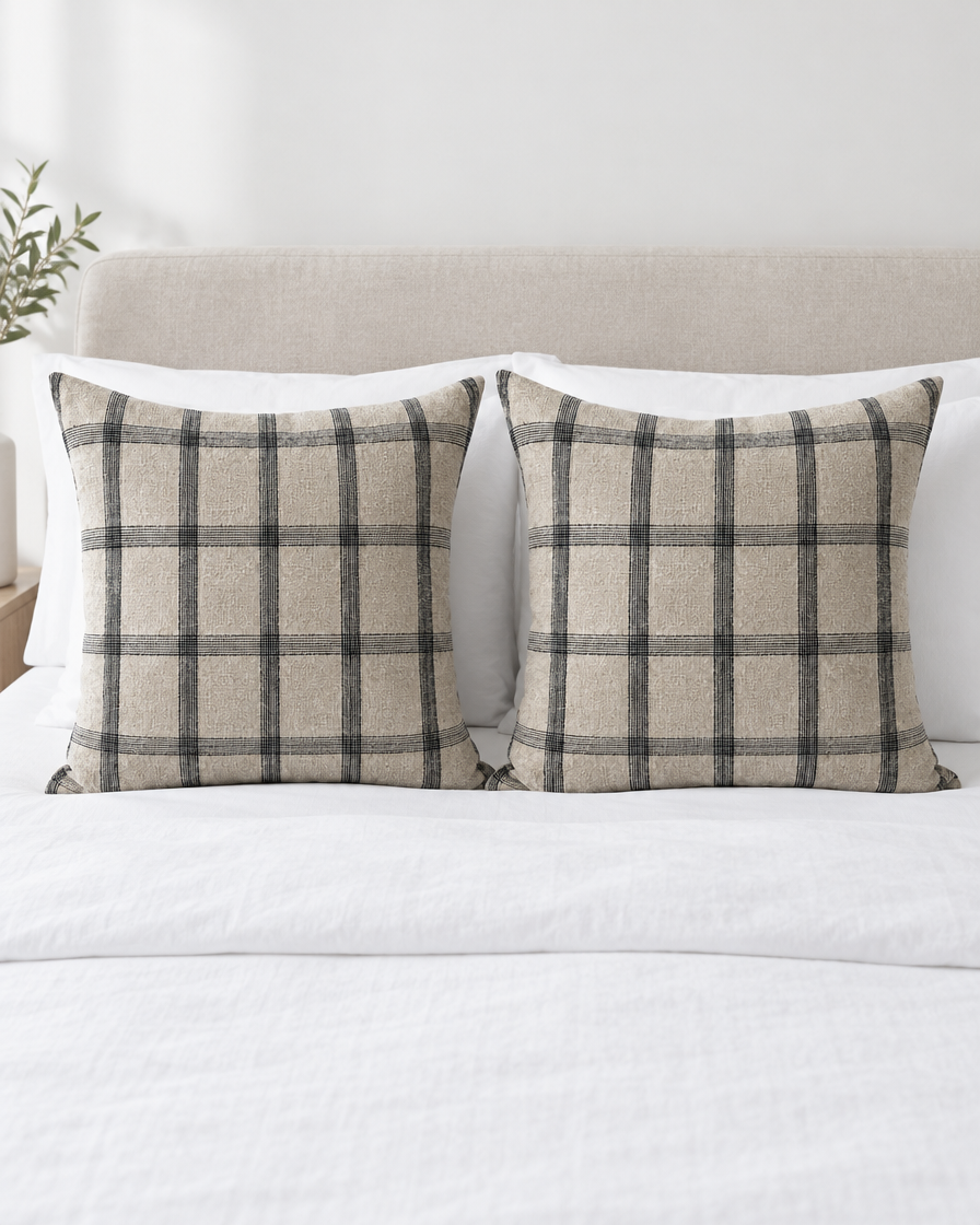 Two Natural Check Tartan Jacquard Linen Cotton cushion covers on a made bed with white bedding