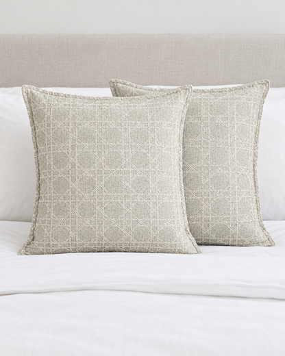 Two Mint Grey Lattice Jacquard cushion covers on a made bed with white bedding