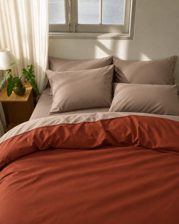 Rust duvet cover with light beige reverse, light beige fitted sheet and light beige pillowcases in Silky Cotton