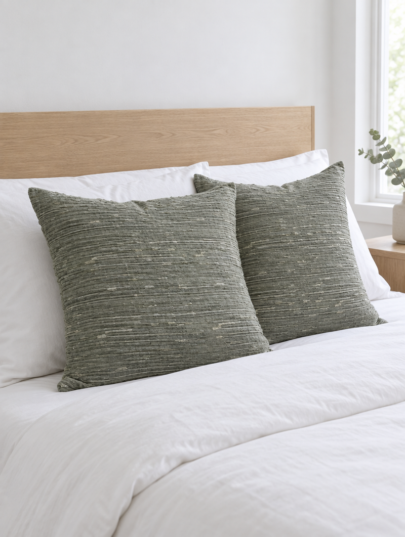 Sage flecked jacquard cotton linen cushions on white bedding with an oak headboard