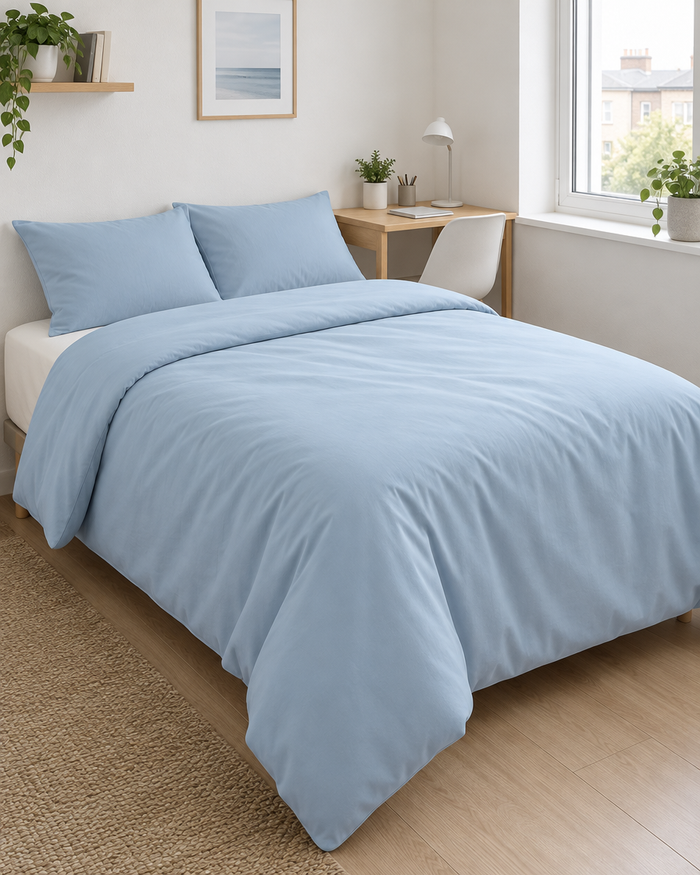Small double bed in baby blue Plain Cotton percale in a compact bedroom