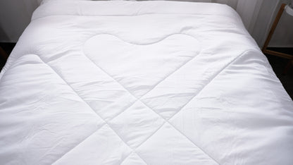 White quilted duvet insert spread across a made bed.
