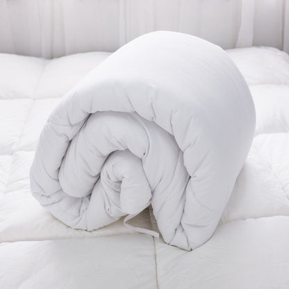 White duvet insert rolled up on a bed.