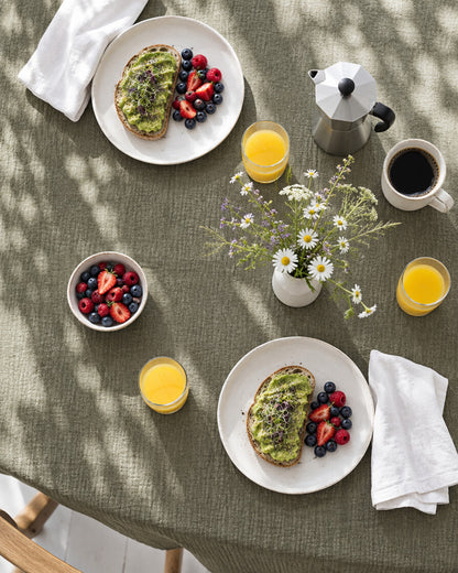 Juniper green cloud cotton tablecloth laid for brunch, seen from above