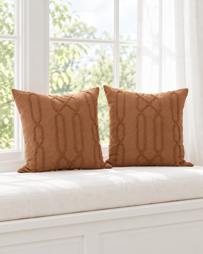 Terracotta trellis embroidered ramie cotton cushions on a white window seat with sheer curtains and garden view