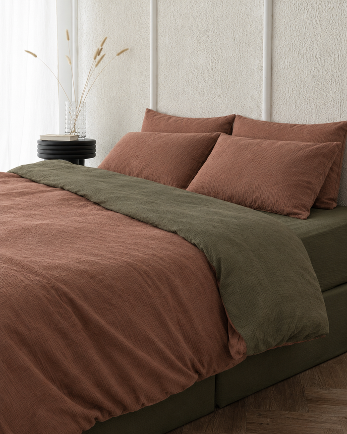 Two tone Cloud Cotton duvet cover in Copper folded back to show a juniper green reverse