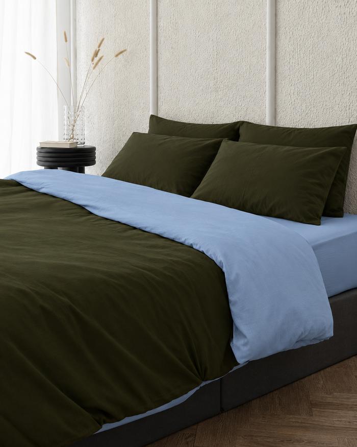 Two tone Plain Cotton duvet cover in Dark Forest folded back to show a sky blue reverse