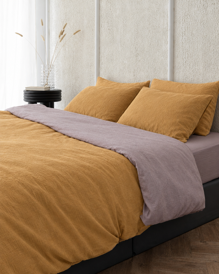 Two tone Cloud Cotton duvet cover in Mustard folded back to show a taro reverse