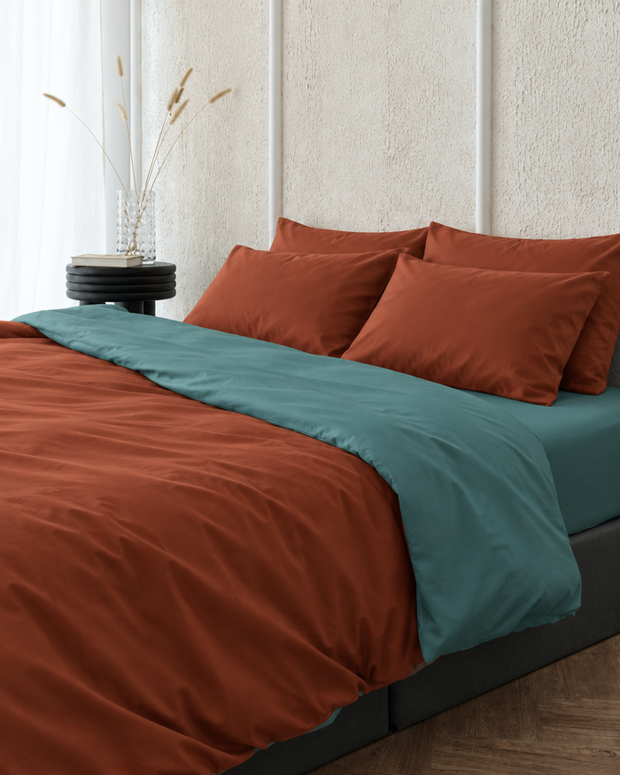 Two tone Silky Cotton duvet cover in Rust folded back to show a pine green reverse