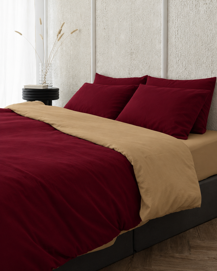 Two tone Plain Cotton duvet cover in Wine Red folded back to show a sand reverse