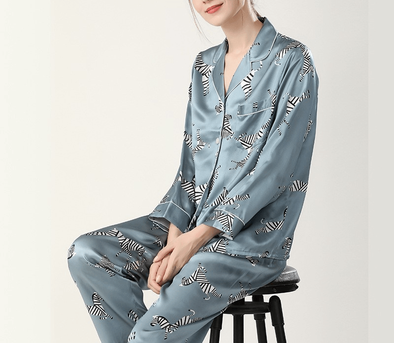 Person wearing a light blue pajama set with zebra pattern on a white background